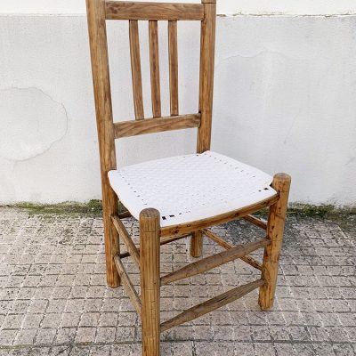 Proyecto de dome creative design studio, restauración de una silla rústica encordada, vista frontal de la silla restaurada, con asiento encordado en algodón blanco y la estructura de madera saneada y encerada