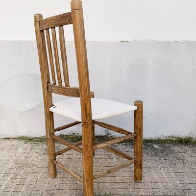 Proyecto de dome creative design studio, restauración de una silla rústica encordada, vista de la parte trasera de la silla restaurada, con asiento encordado en algodón blanco y la estructura de madera saneada y encerada